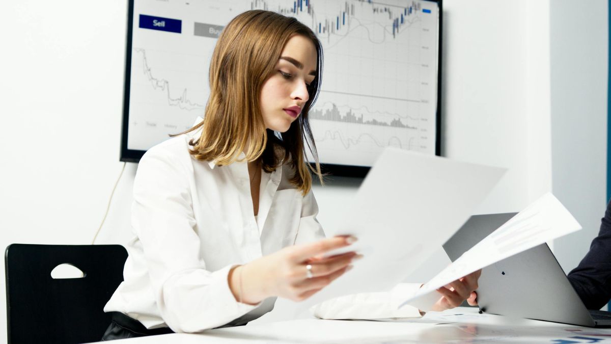 A person analyzing data charts and observing patterns, symbolizing future trend prediction